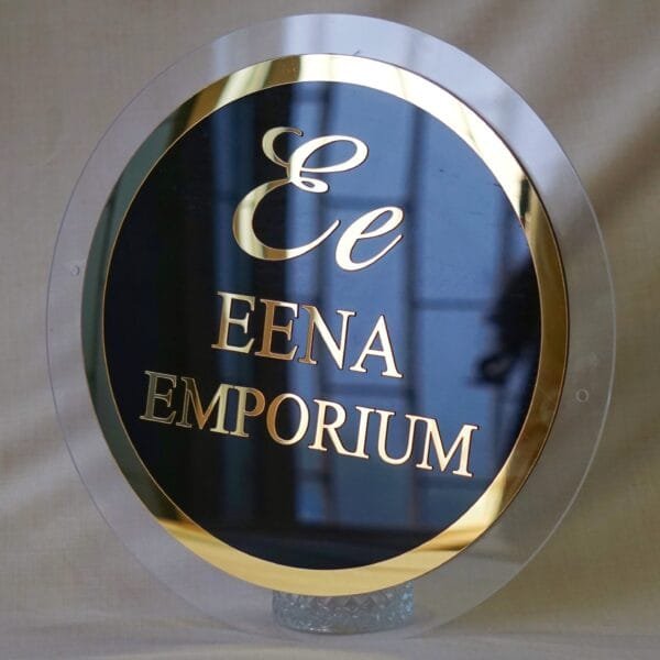 black and golden signage in circular shape with 3d embossed letters and logo