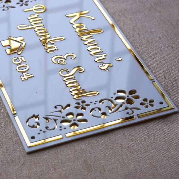 Rectangular white and gold nameplate with floral design, customizable name option.