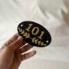 acrylic numberplate in black and gold color and oval shape