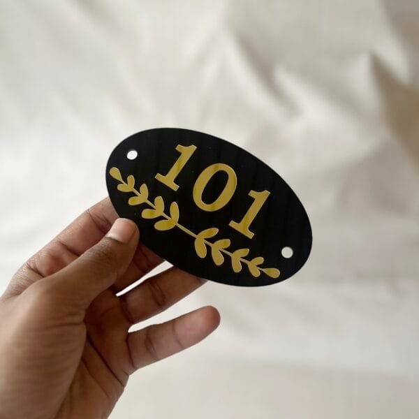 acrylic numberplate in black and gold color and oval shape