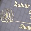 White and golden acrylic Arabic calligraphy name plate in a rectangular shape, measuring 12x8 inches with name, room number, and elegant Arabic calligraphy.