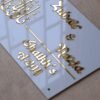 White and golden acrylic Arabic calligraphy name plate in a rectangular shape, measuring 12x8 inches with name, room number, and elegant Arabic calligraphy.