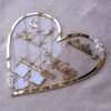 personalized wedding thumb board in heart-shaped design with floral embellishments, this nikah thumb board is made using golden and transparent acrylic sheets. It is used as a wedding keepsake that can be showcased on a cabinet.
