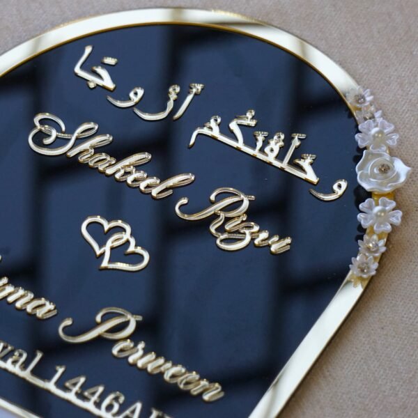 Black and gold acrylic Nikah thumb board with customizable names, ideal for Muslim wedding ceremonies.