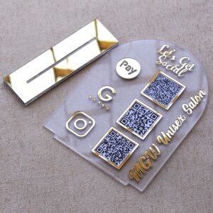 A customizable QR code stand made using imported acrylic and golden sheets is perfect for business desks and exhibitions. The QR codes and brand name can be customized. The stand is removable, and the size of the product is 5 by 7 inches.
