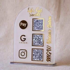 A customizable QR code stand made using imported acrylic and golden sheets is perfect for business desks and exhibitions. The QR codes and brand name can be customized. The stand is removable, and the size of the product is 5 by 7 inches.