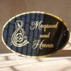 Black oval acrylic nameplate with gold Arabic calligraphy, featuring a small dangling gold heart plate embossed with the child’s name—a personalized, elegant keepsake for your home.