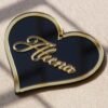 Black oval acrylic nameplate with gold Arabic calligraphy, featuring a small dangling gold heart plate embossed with the child’s name—a personalized, elegant keepsake for your home.