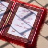 A red fur–clad nikah nama booklet with an acrylic cover and MDF backing, opened to blank pages for the bride’s and groom’s thumbprints and signatures as a lasting wedding keepsake