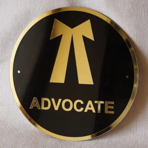 Round 3D embossed advocate signboard, which features a logo. The color combination of this signboard is black and gold, which gives a professional look to the lawyer's office.