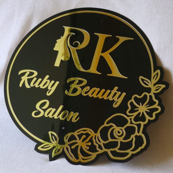 Custom beauty salon sign in black and gold acrylic with a floral design, shown on a white background.