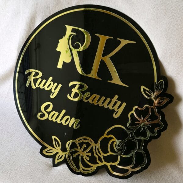 1000014747 Custom beauty salon sign in black and gold acrylic with a floral design, shown on a white background.