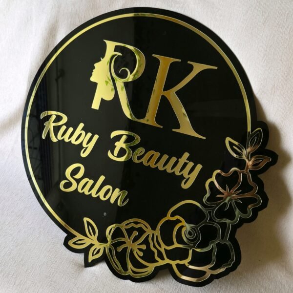 Custom beauty salon sign in black and gold acrylic with a floral design, shown on a white background.