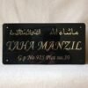 1751193545780 Front view of a personalized 'TAHA MANZIL' Islamic name plate in black acrylic with gold Arabic calligraphy reading 'MashaAllah'.