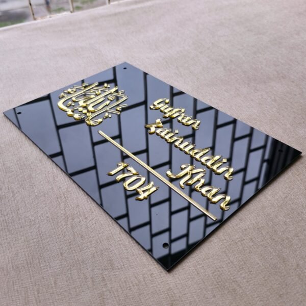 20250616_125118 A high-angle shot of a personalised Islamic nameplate, showcasing the 3D golden calligraphy and letters reflecting a window on its glossy black acrylic surface.