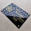 20250616_125614 ngled view of a Masha'Allah Islamic acrylic nameplate in black and gold, showing the silver mounting studs and custom name 'Gufran Zainuddin Khan'.