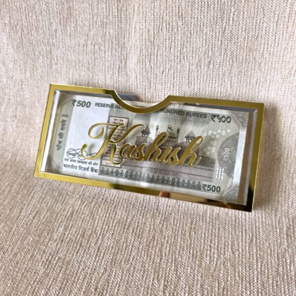 Angled view of a personalized Rakhi money envelope with the name 'Kashish' in 3D gold acrylic script, highlighting its premium quality and custom feel.