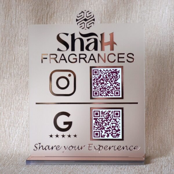 Front view of a personalized business QR code stand in matte and rose gold for 'Shah Fragrances', showing Instagram and Google review QR codes.