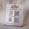 Angled view of a custom rose gold acrylic QR code stand for 'Shah Fragrances' on its display base, showing its 3D profile.