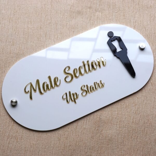 Angled view of the 'Male Section' shop sign, showing the glossy finish of the white acrylic and raised gold letters.
