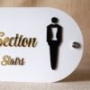 Detailed close-up of the black male tuxedo icon on the premium 'Male Section' store sign.