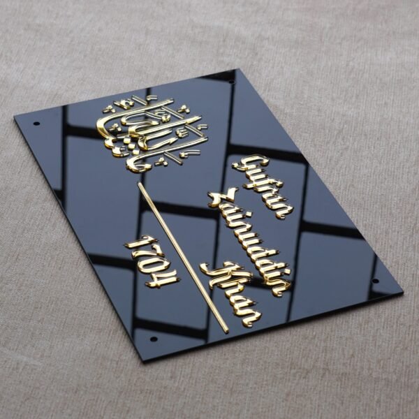 DSC08178 Angled top-down view of the Masha'Allah Islamic calligraphy nameplate, showing the 3D depth of the golden acrylic lettering against a reflective black background.