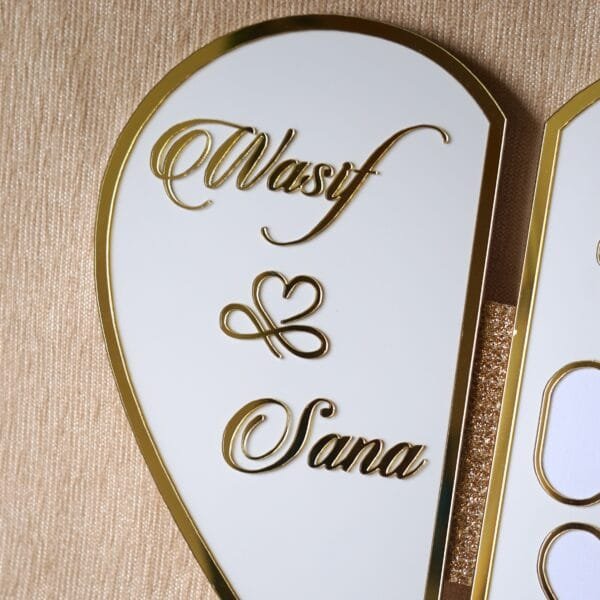 DSC08310 Close-up shot of the left side of the heart plaque, highlighting the elegant gold script of the names 'Wasif & Sana'.