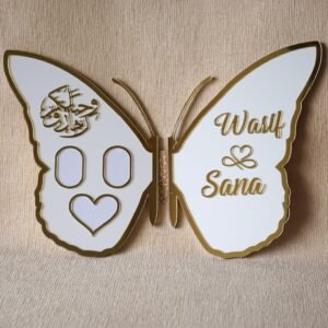 Full view of an open white and gold butterfly nikah thumb board, customized with names 'Wasif & Sana' on one wing and Arabic calligraphy with photo slots on the other.