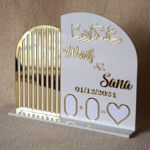 DSC08339 A clear, front-facing view of the personalised Nikah thumb board for 'Wasif & Sana', highlighting the shiny gold acrylic lettering and date against the white plaque.