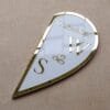 A glossy, angled shot of the closed half of the heart-shaped plaque, featuring custom initials and the wedding date in gold.