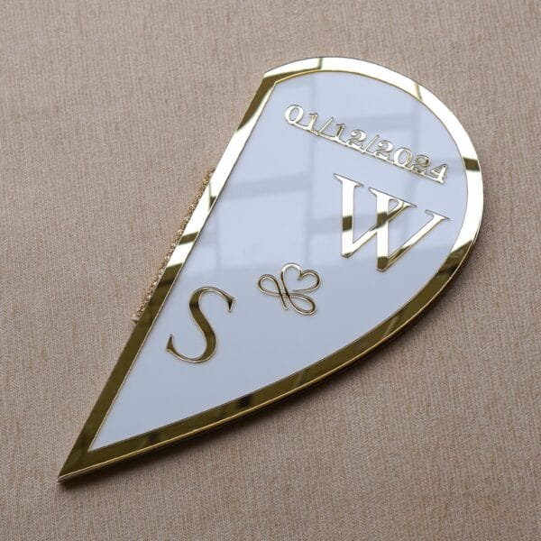 DSC08348 A glossy, angled shot of the closed half of the heart-shaped plaque, featuring custom initials and the wedding date in gold.