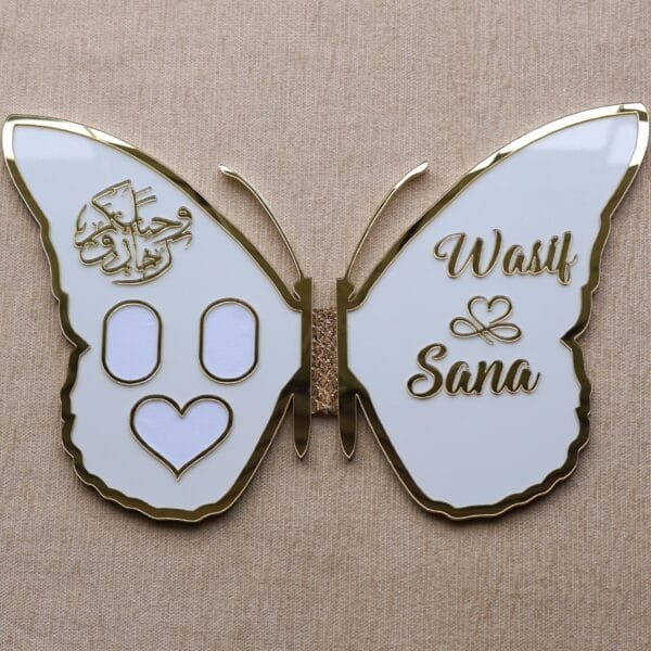 DSC08362 A personalized butterfly-shaped nikah keepsake board in white and gold, open to display the names 'Wasif & Sana' and Arabic calligraphy.