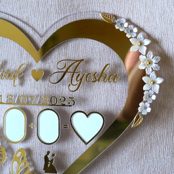 Close-up on the right side of the heart-shaped wedding keepsake, showing the delicate white and gold floral embellishments.