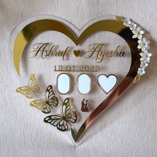 Full front view of a heart-shaped acrylic Nikah thumb board, personalized with the names 'Ashraf & Ayesha' and a date.