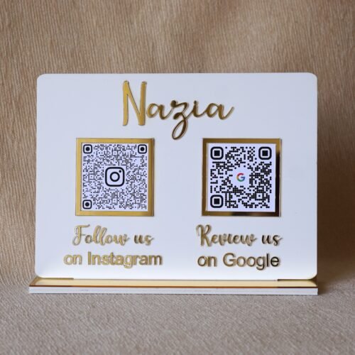 Front view of a custom white acrylic QR code stand with gold accents, personalized with the name 'Nazia' and featuring QR codes for 'Follow us on Instagram' and 'Review us on Google'.