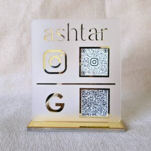 20250809_152659 Front-facing view of the premium matte and gold acrylic QR code stand for Instagram and Google, customized for the brand 'ashtar'.
