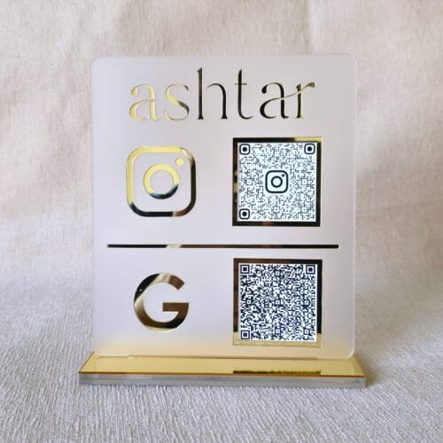 Front-facing view of the premium matte and gold acrylic QR code stand for Instagram and Google, customized for the brand 'ashtar'.