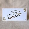 A custom white and gold acrylic nameplate for Islamic home decor, featuring the name 'Jannat' in elegant Arabic calligraphy with decorative leaf motifs in the corners.