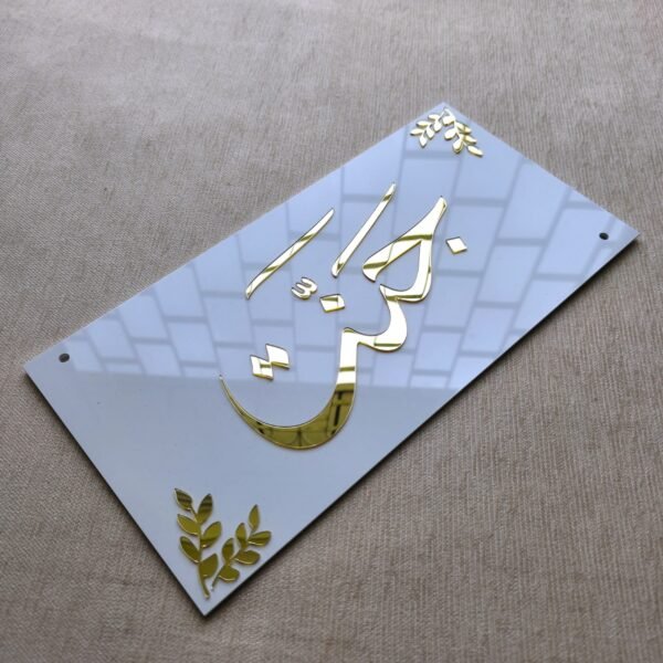 Example of a personalized acrylic nameplate showing the name 'Kausar' in custom gold Urdu calligraphy, highlighting the product's customization options.