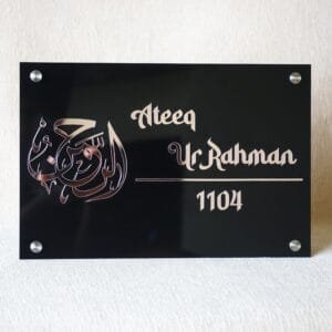 anp1 Front view of a custom Islamic name plate in black acrylic with rose gold Arabic calligraphy for 'Al-Rahman' and the name 'Ateeq Ur Rahman'.