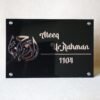 Front view of a custom Islamic name plate in black acrylic with rose gold Arabic calligraphy for 'Al-Rahman' and the name 'Ateeq Ur Rahman'.