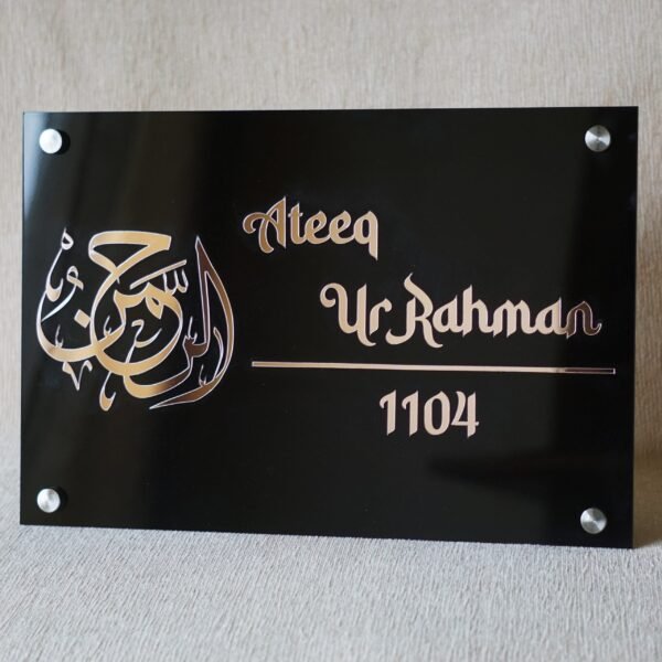 A clear, straight-on shot of the personalized black and rose gold house name plate with the number 1104.
