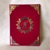 Closed red velvet-textured Nikah Nama booklet with a custom gold acrylic monogram 'IH' in an ornate central design.
