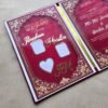 Angled perspective shot of the open Nikah Nama booklet, displaying the custom gold names and the marriage agreement page.