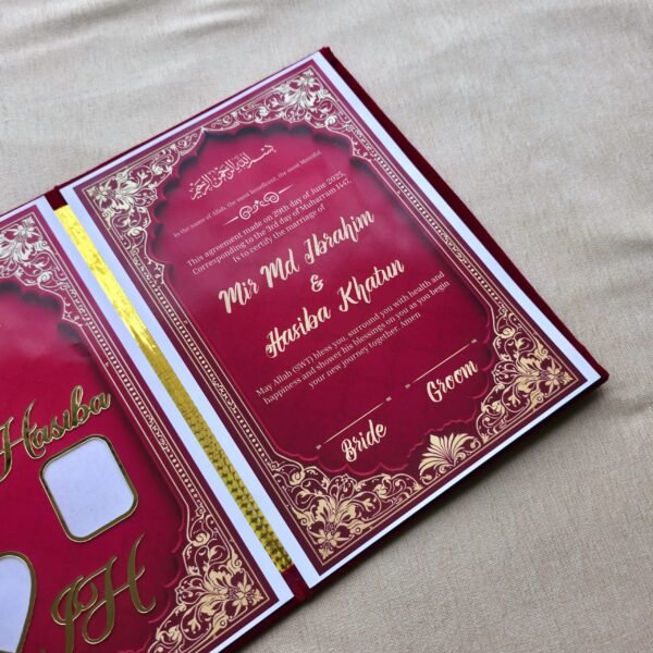 A high-angle perspective view of the open red Nikah Nama booklet, focusing on the marriage certificate page with its intricate gold border.
