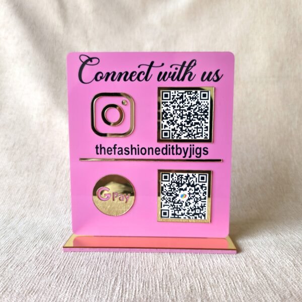 qr1 Front view of the assembled pink and gold acrylic QR code stand showing Instagram and GPay codes, customized for 'thefashioneditbyjigs'.