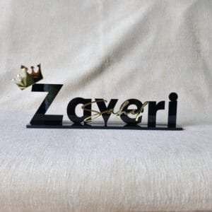 20250829_125705 Custom black acrylic desk nameplate for 'Sahel Zaveri' with a gold crown, shown from the front on a beige textured background.