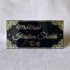 Front view of a personalized black acrylic nameplate with 'Mr. Mohd. Ibrahim Shaikh C-8' in 3D golden letters and decorative gold corners.
