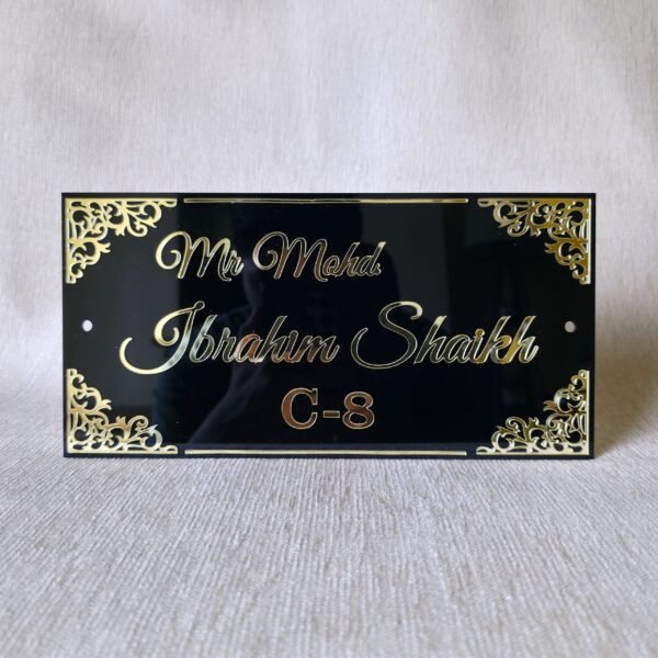 20250830_153123 Front view of a personalized black acrylic nameplate with 'Mr. Mohd. Ibrahim Shaikh C-8' in 3D golden letters and decorative gold corners.