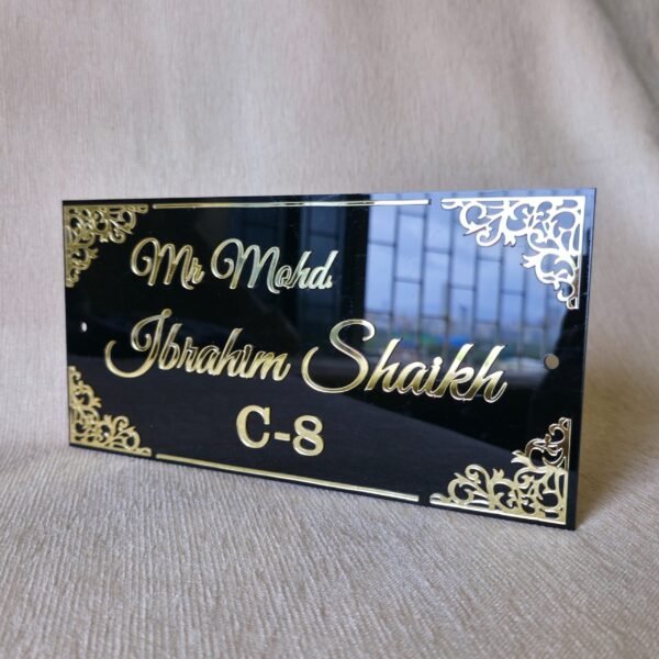 20250830_153256 Angled view of the black and gold acrylic nameplate showing the glossy, reflective surface and 3D embossed text.